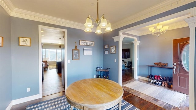 dining room with dark wood-type flooring, crown molding, decorative columns, and a chandelier