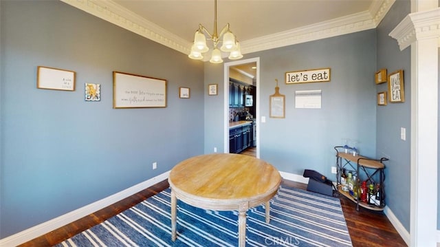 dining room with crown molding, an inviting chandelier, and dark hardwood / wood-style floors