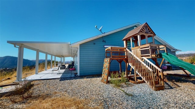 view of play area with a patio and a mountain view