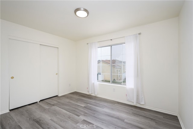 unfurnished bedroom with a closet and light wood-type flooring