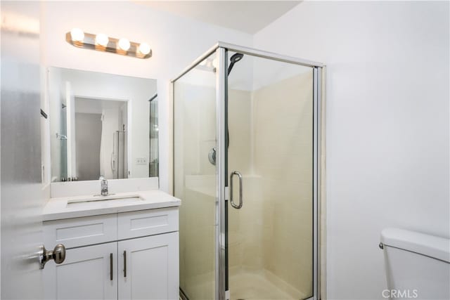 bathroom with vanity, toilet, and an enclosed shower