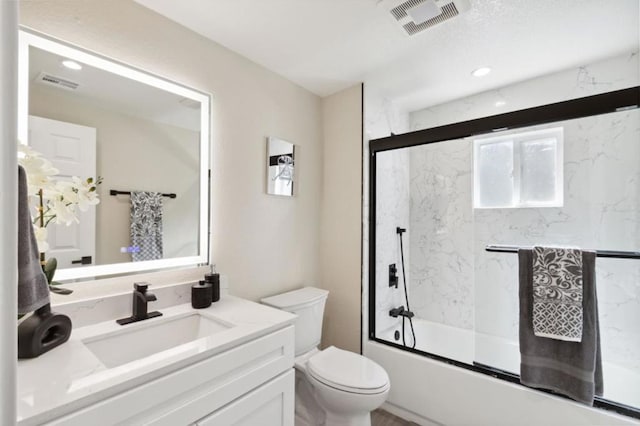 full bathroom featuring toilet, vanity, and shower / bath combination with glass door