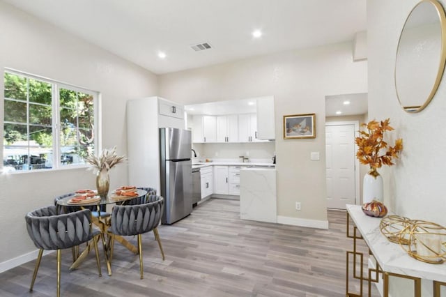 kitchen with white cabinetry, appliances with stainless steel finishes, and light wood-type flooring