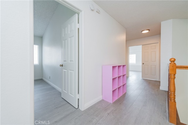 hallway featuring a textured ceiling and light wood-type flooring