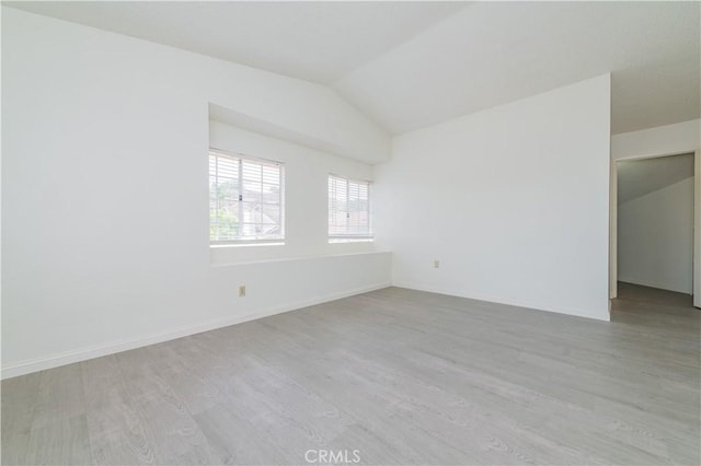 unfurnished room featuring lofted ceiling and wood finished floors