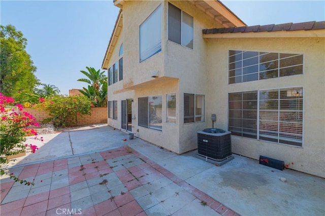 back of house with a patio, central air condition unit, stucco siding, and a fenced backyard