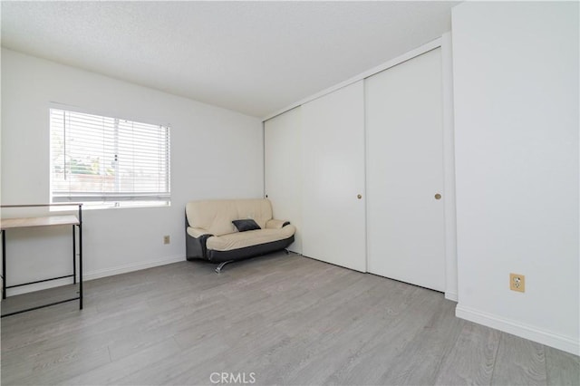 sitting room featuring baseboards and wood finished floors