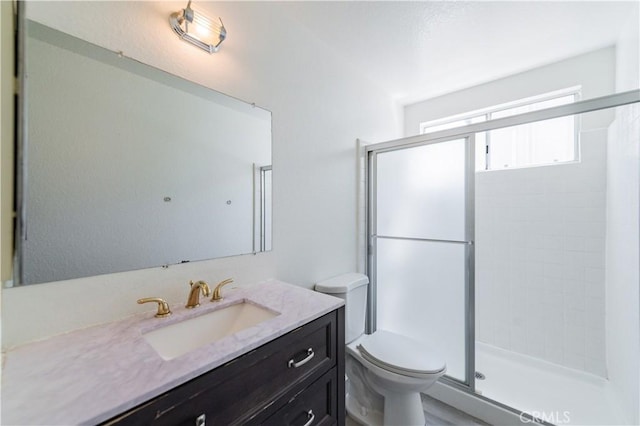 full bathroom with a stall shower, toilet, and vanity