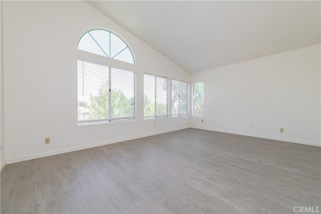 unfurnished room with baseboards, wood finished floors, and a healthy amount of sunlight