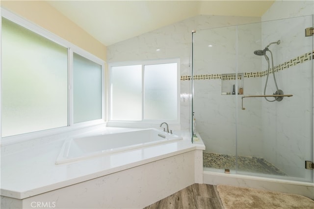 bathroom featuring lofted ceiling, hardwood / wood-style floors, and plus walk in shower