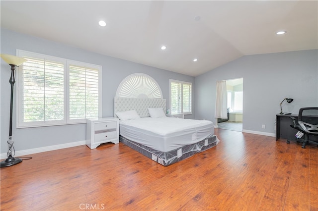 bedroom with wood-type flooring and vaulted ceiling