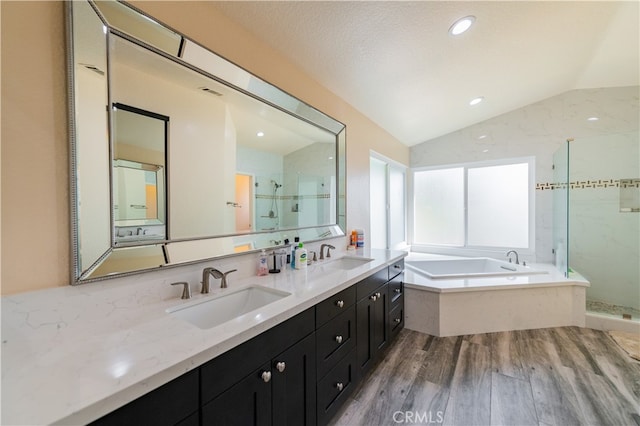 bathroom with vanity, hardwood / wood-style floors, vaulted ceiling, and plus walk in shower