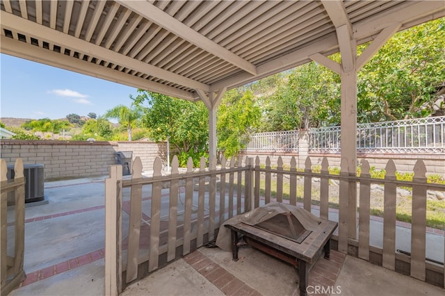 view of patio featuring central air condition unit and a fire pit