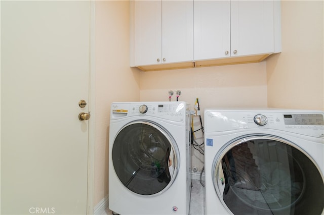 laundry area featuring cabinets and washing machine and clothes dryer