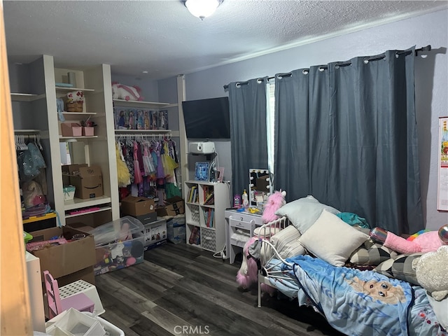 bedroom with dark wood-type flooring, a textured ceiling, and a closet