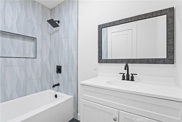 bathroom featuring tiled shower / bath combo and vanity