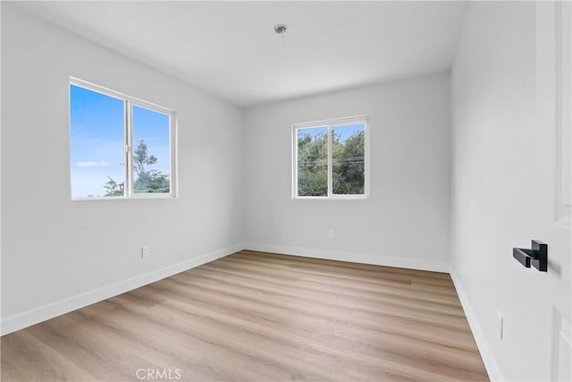 spare room featuring light hardwood / wood-style floors and plenty of natural light