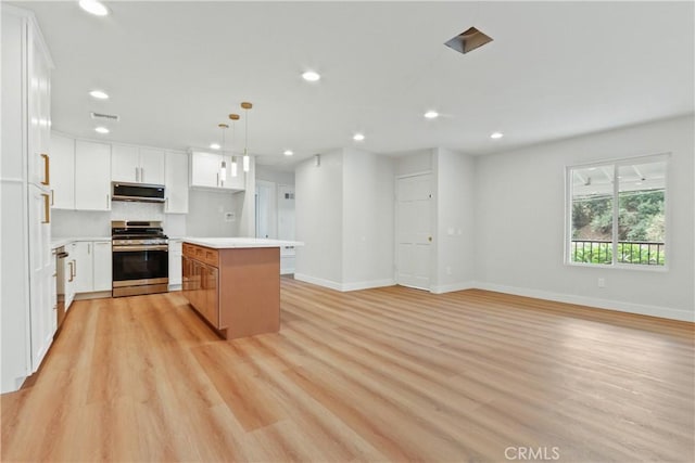 kitchen featuring pendant lighting, white cabinets, stainless steel appliances, and a kitchen island