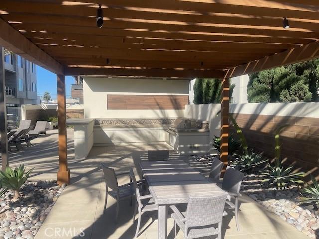 view of patio with an outdoor kitchen and a pergola