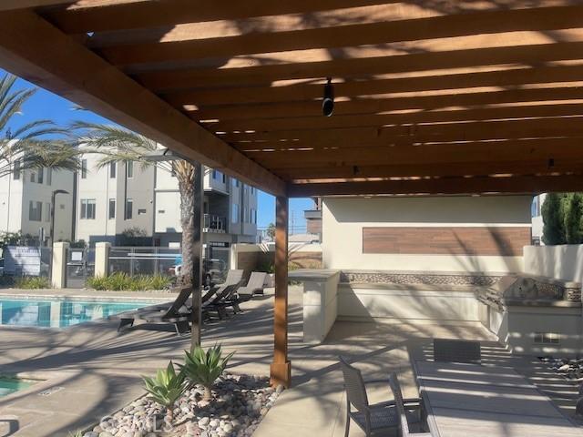 view of patio featuring exterior kitchen and a community pool