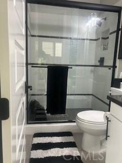 bathroom featuring walk in shower, vanity, and toilet