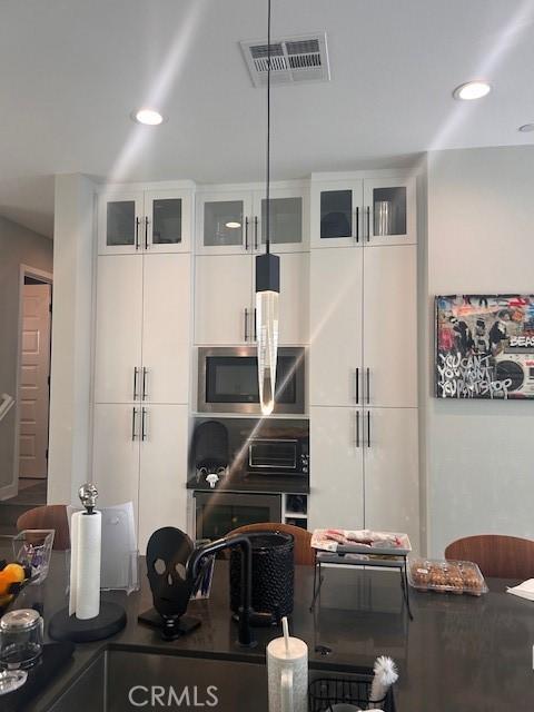 kitchen featuring white cabinets and stainless steel microwave