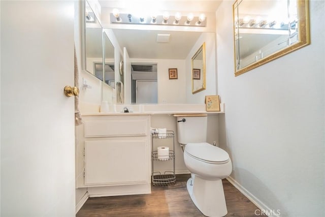 bathroom with hardwood / wood-style flooring, vanity, and toilet