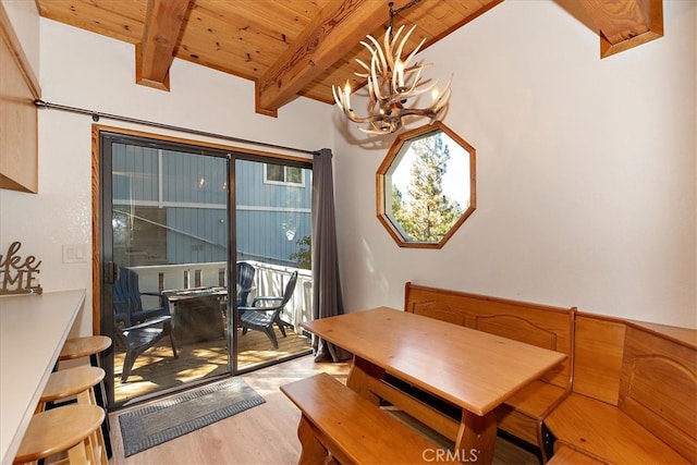 dining space with light hardwood / wood-style flooring, wood ceiling, a chandelier, and vaulted ceiling with beams