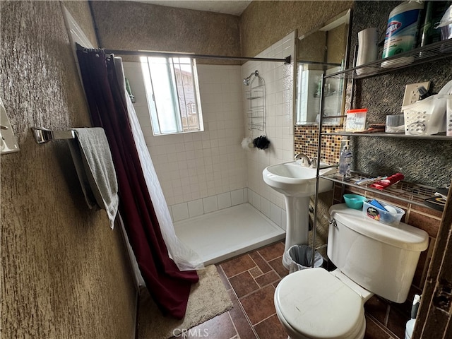 bathroom featuring decorative backsplash, toilet, tile patterned flooring, sink, and curtained shower