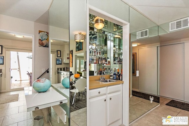 bar with white cabinetry and sink