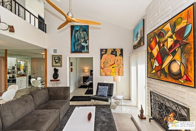 tiled living room featuring high vaulted ceiling, a brick fireplace, and ceiling fan