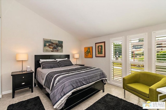 bedroom featuring light tile patterned floors, multiple windows, and lofted ceiling