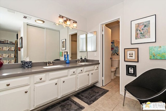 bathroom with tile patterned flooring, vanity, and toilet