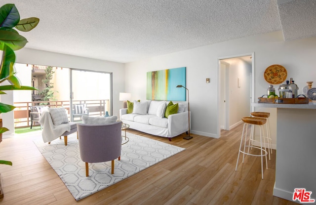 living room featuring a textured ceiling and light hardwood / wood-style floors