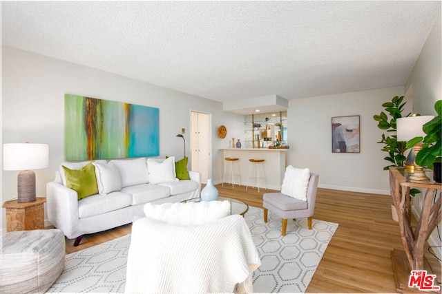 living room with light hardwood / wood-style floors and a textured ceiling