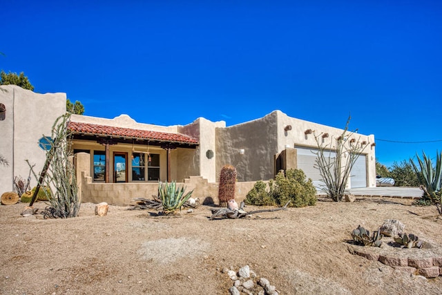 pueblo revival-style home featuring a garage