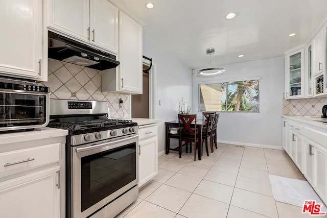 kitchen with white cabinets, light tile patterned flooring, backsplash, and stainless steel gas range