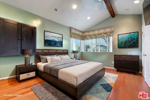 bedroom with light hardwood / wood-style floors and vaulted ceiling with beams