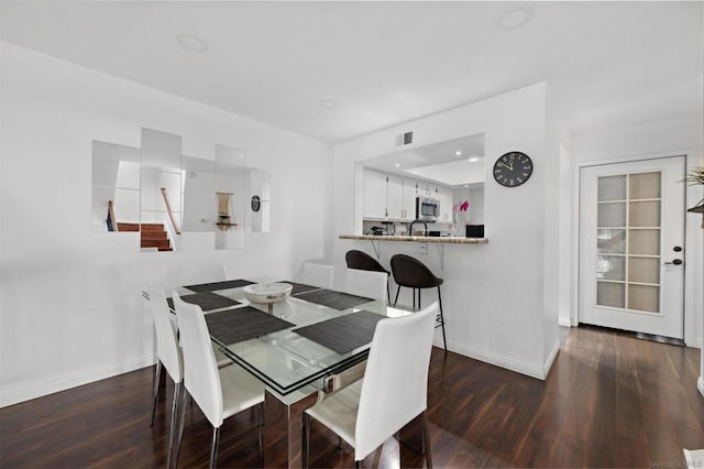 dining space with dark hardwood / wood-style flooring