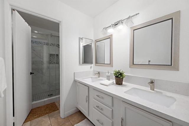 bathroom with a shower with door, vanity, and tile patterned floors