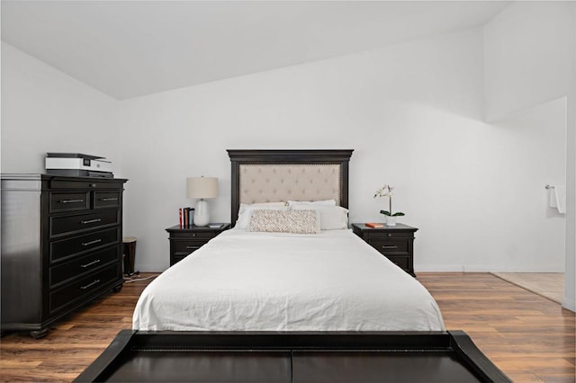 bedroom with lofted ceiling and dark hardwood / wood-style flooring