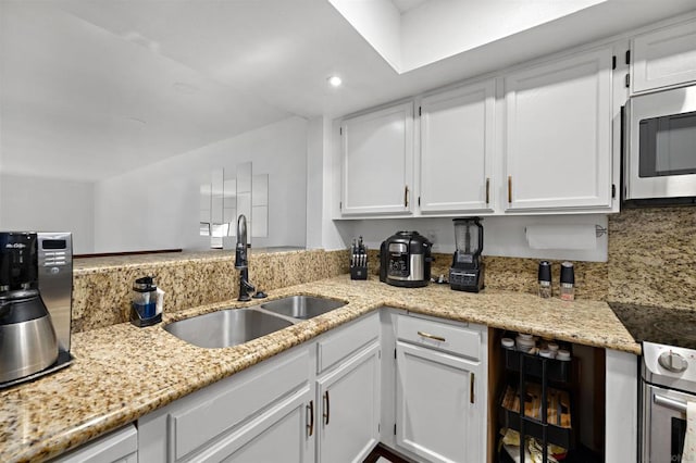 kitchen featuring white cabinetry, backsplash, stainless steel appliances, and sink