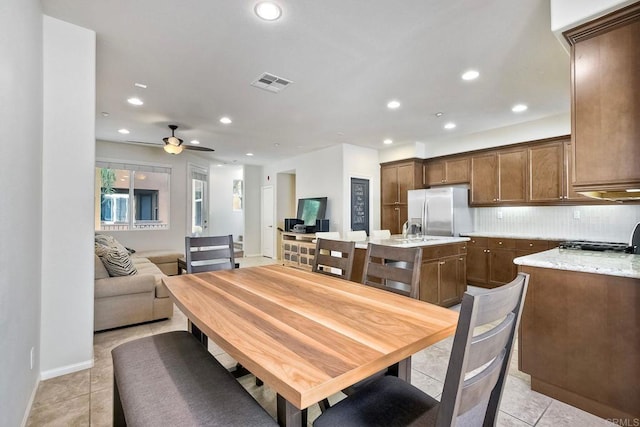 tiled dining area featuring ceiling fan and sink