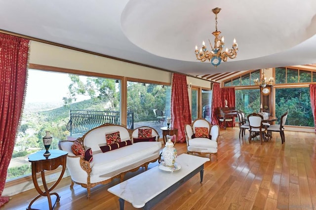 living room with vaulted ceiling, light hardwood / wood-style flooring, and a chandelier