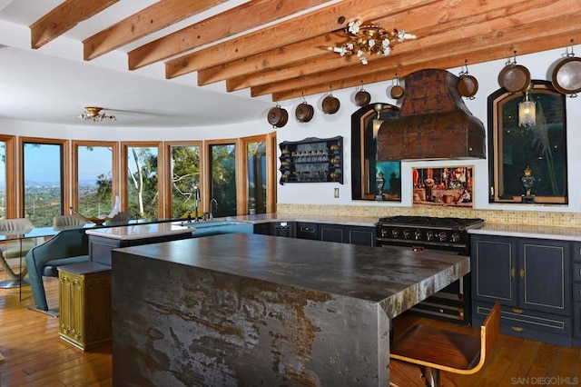 kitchen with decorative backsplash, dark hardwood / wood-style flooring, extractor fan, high end black range oven, and a breakfast bar area