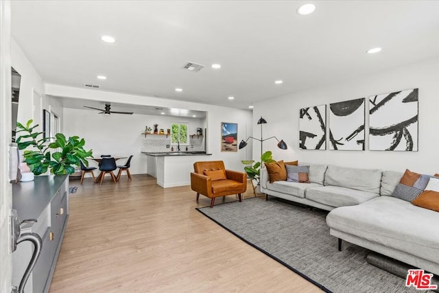 living room featuring light wood-type flooring and ceiling fan