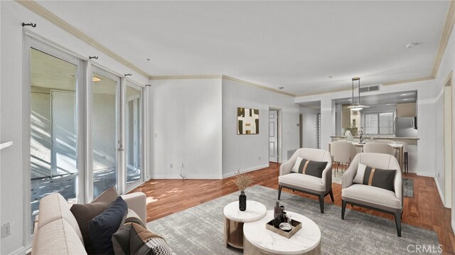 living room with crown molding and wood-type flooring