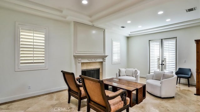 living room featuring beam ceiling and a tiled fireplace