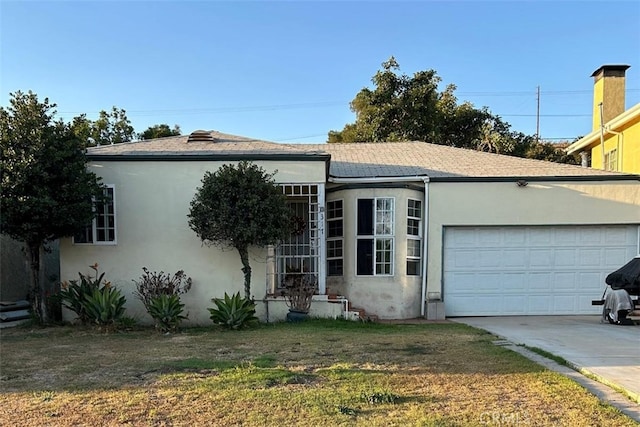 view of front of property with a front yard and a garage