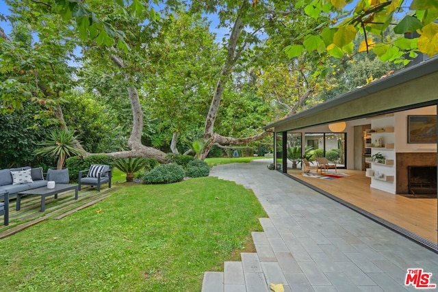 view of yard featuring an outdoor living space and a patio area